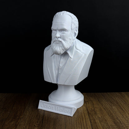 A white bust of a bearded man wearing a suit, placed on a wooden surface.
