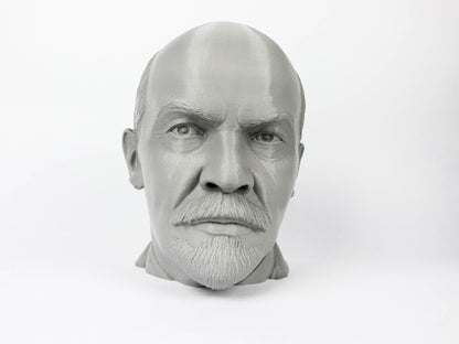 A black and white image of a man's head, possibly a bust, with a serious expression on his face.
