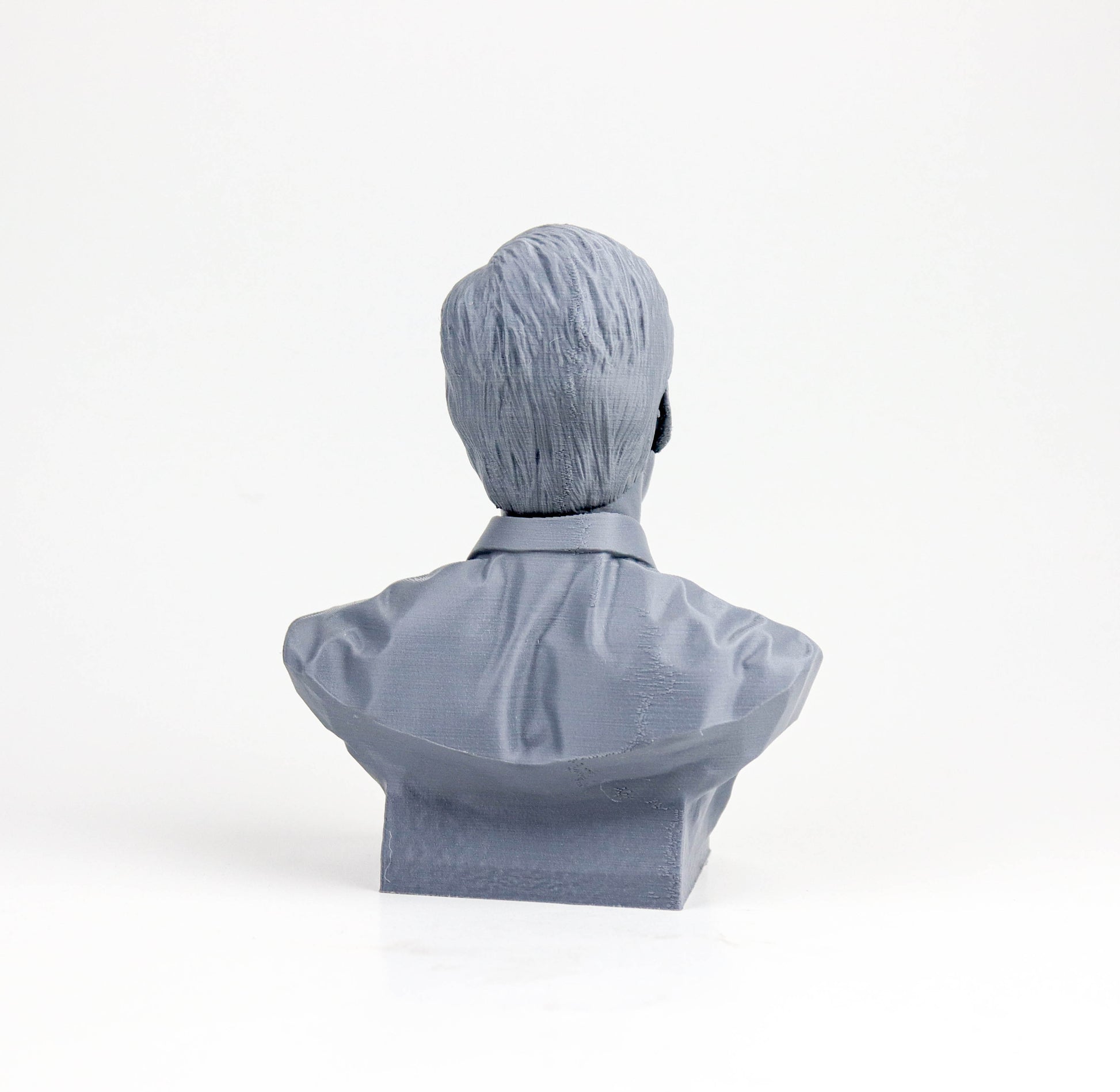 A gray bust sculpture of a person facing away from the camera.