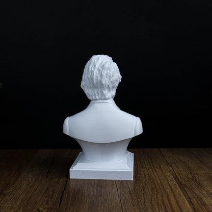 A white bust sculpture of a person is displayed on a wooden surface against a black background.