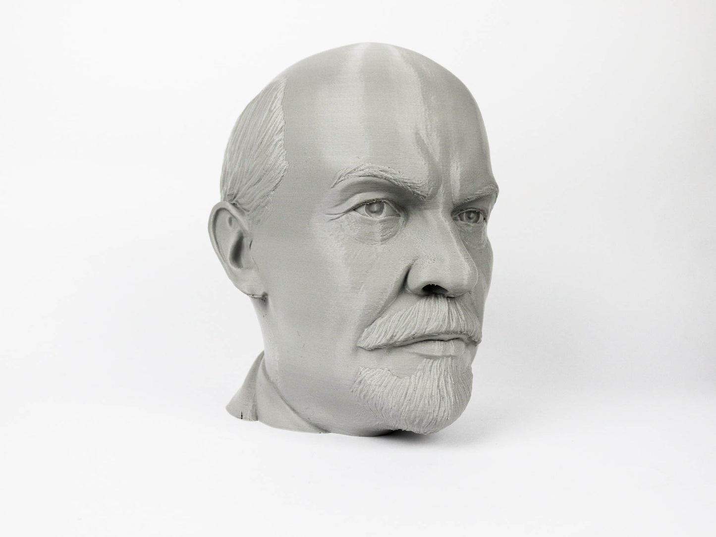 A gray bust of a man's head, with a serious expression, is shown against a plain white background.