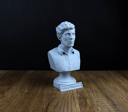 A white bust of a man is displayed on a wooden surface, with a small plaque in front of it.