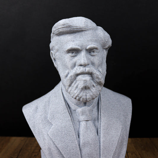 A gray stone bust sculpture depicting a man with a beard wearing a suit and tie.