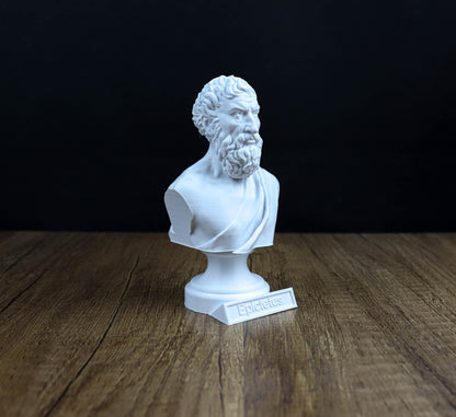 A white bust of a bearded man, likely depicting the Greek poet Epidaurus, is displayed on a wooden surface against a black background.