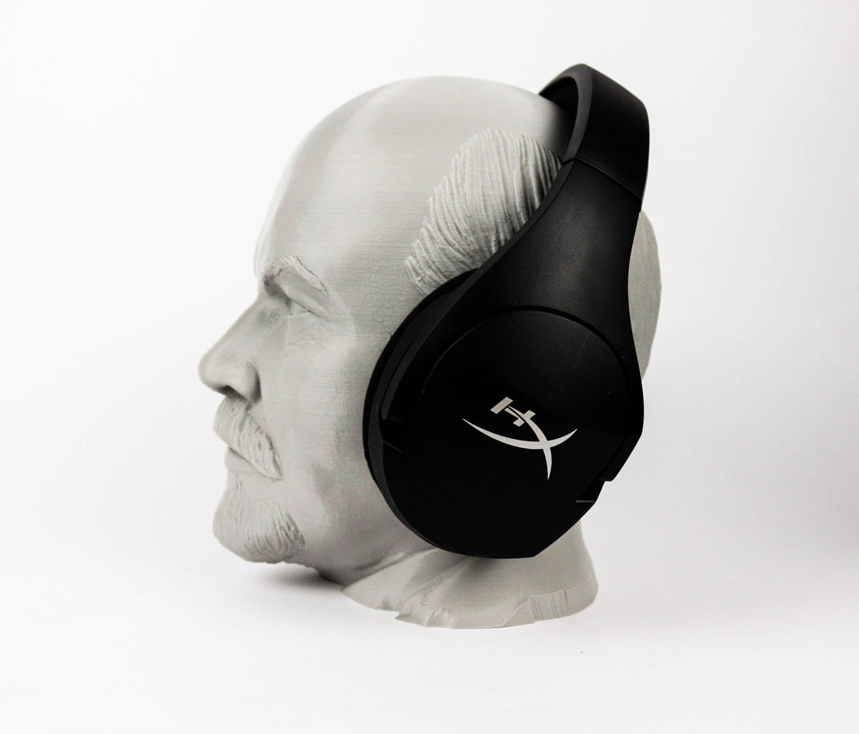 A black and white image of a head wearing a pair of headphones.
