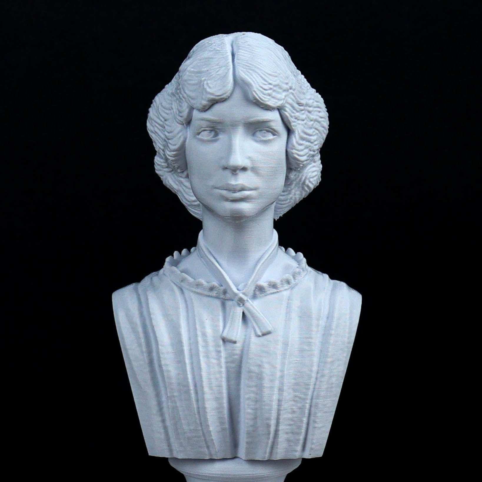 A white bust sculpture of a woman with curly hair and a pensive expression, set against a black background.