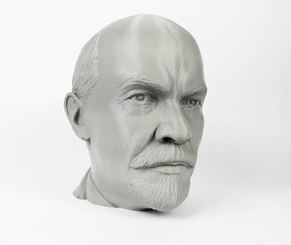 A gray bust of a man's head, with a serious expression and a mustache.