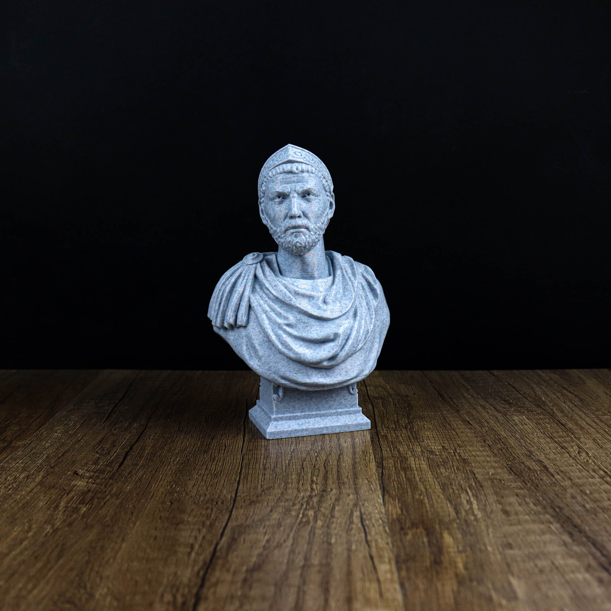 A white bust of a man is displayed on a wooden surface against a black background.