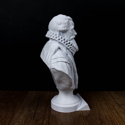 A white bust of a man with a beard is displayed on a wooden surface against a black background.