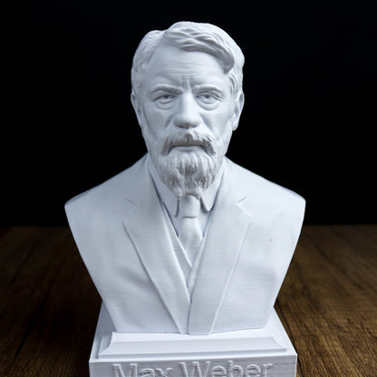 A white bust sculpture of a man with a beard and mustache, wearing a suit and tie, sitting on a wooden surface.