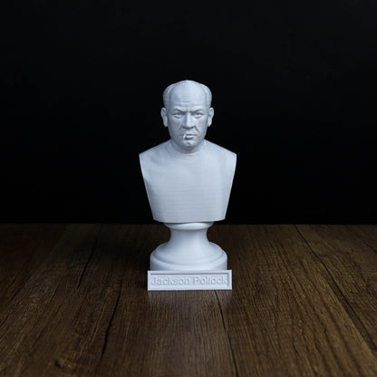A white bust of a man's head is displayed on a wooden surface against a black background.